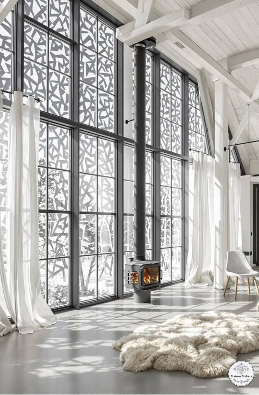 a living room with large windows and a rug on the floor