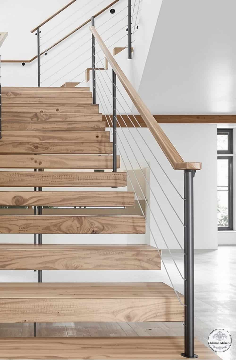 a wooden stair case with metal handrails