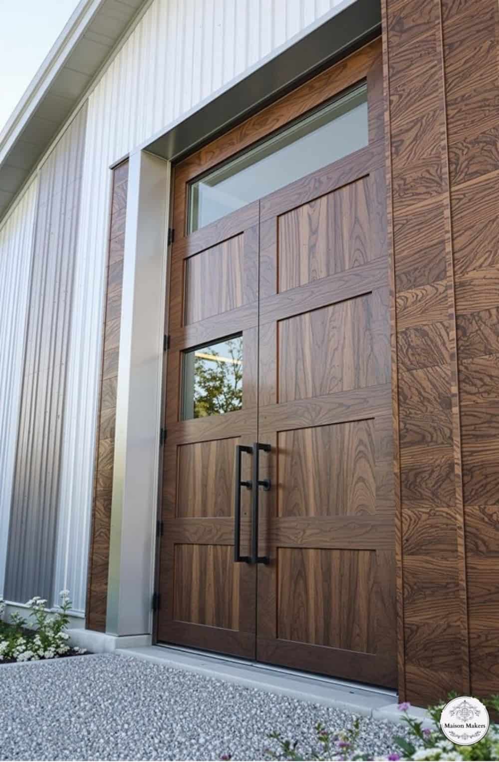 a large wooden garage door sitting next to a white building