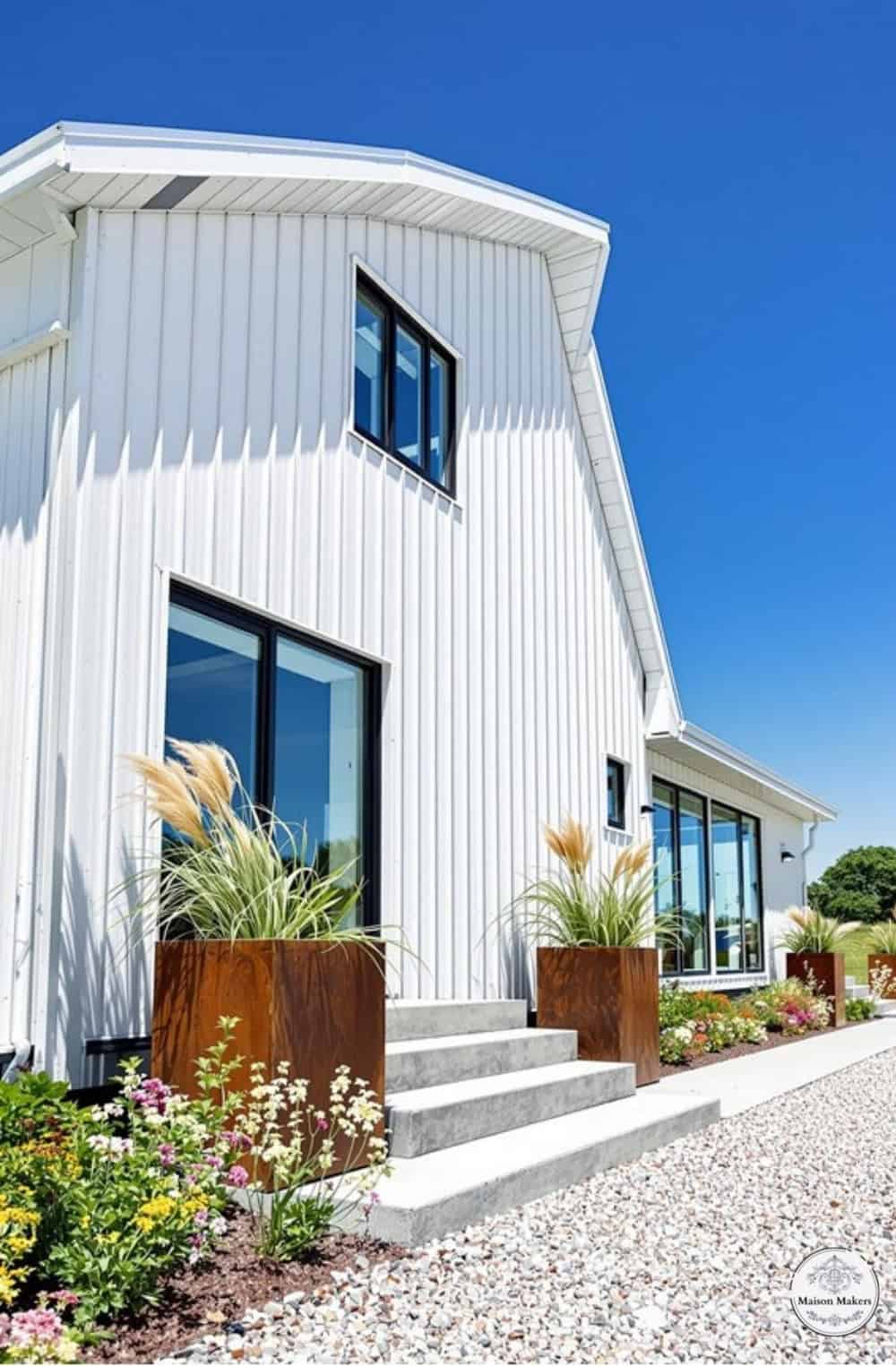 a white house with a lot of windows and plants