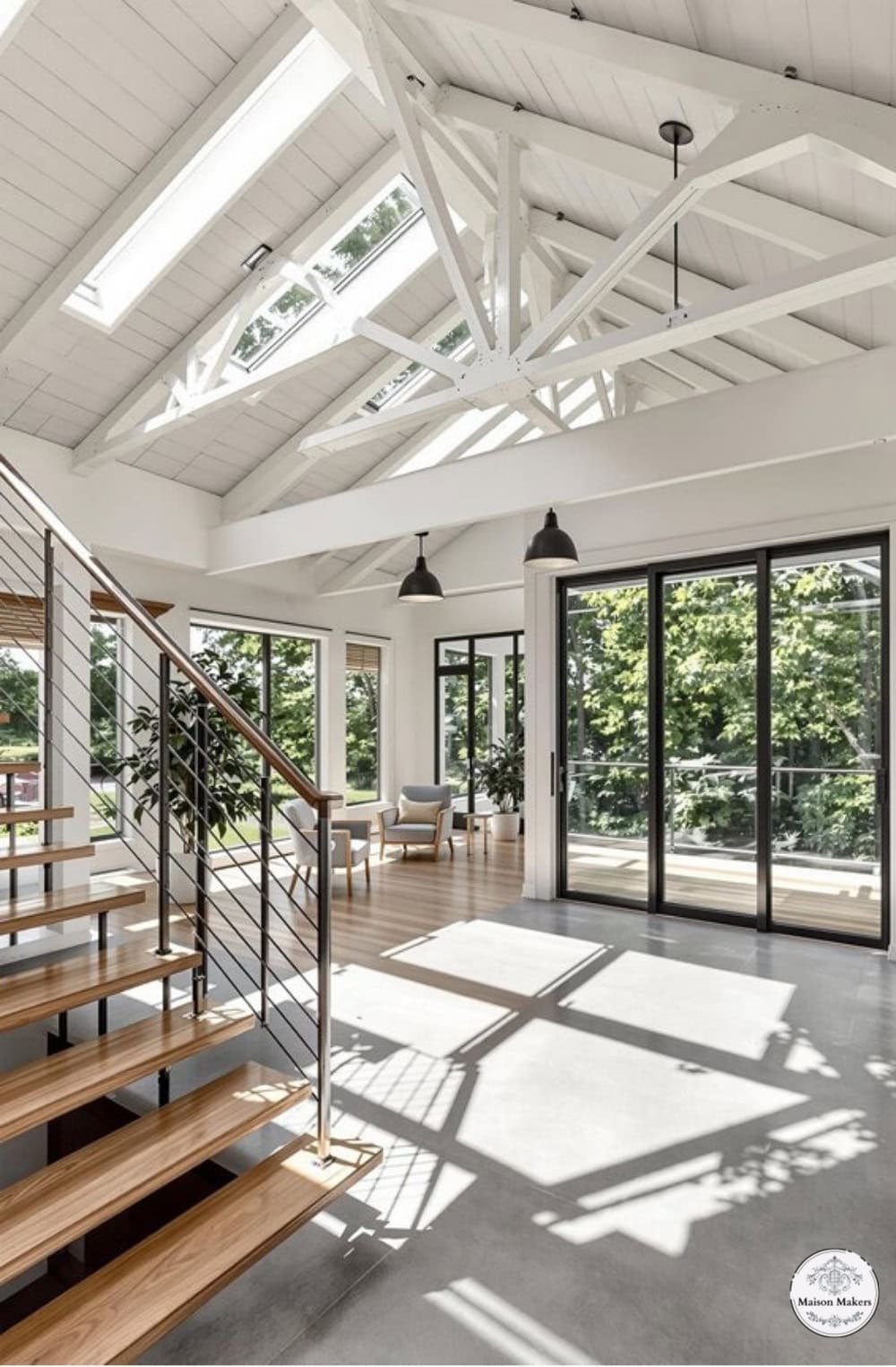 a living room with a lot of windows and a staircase
