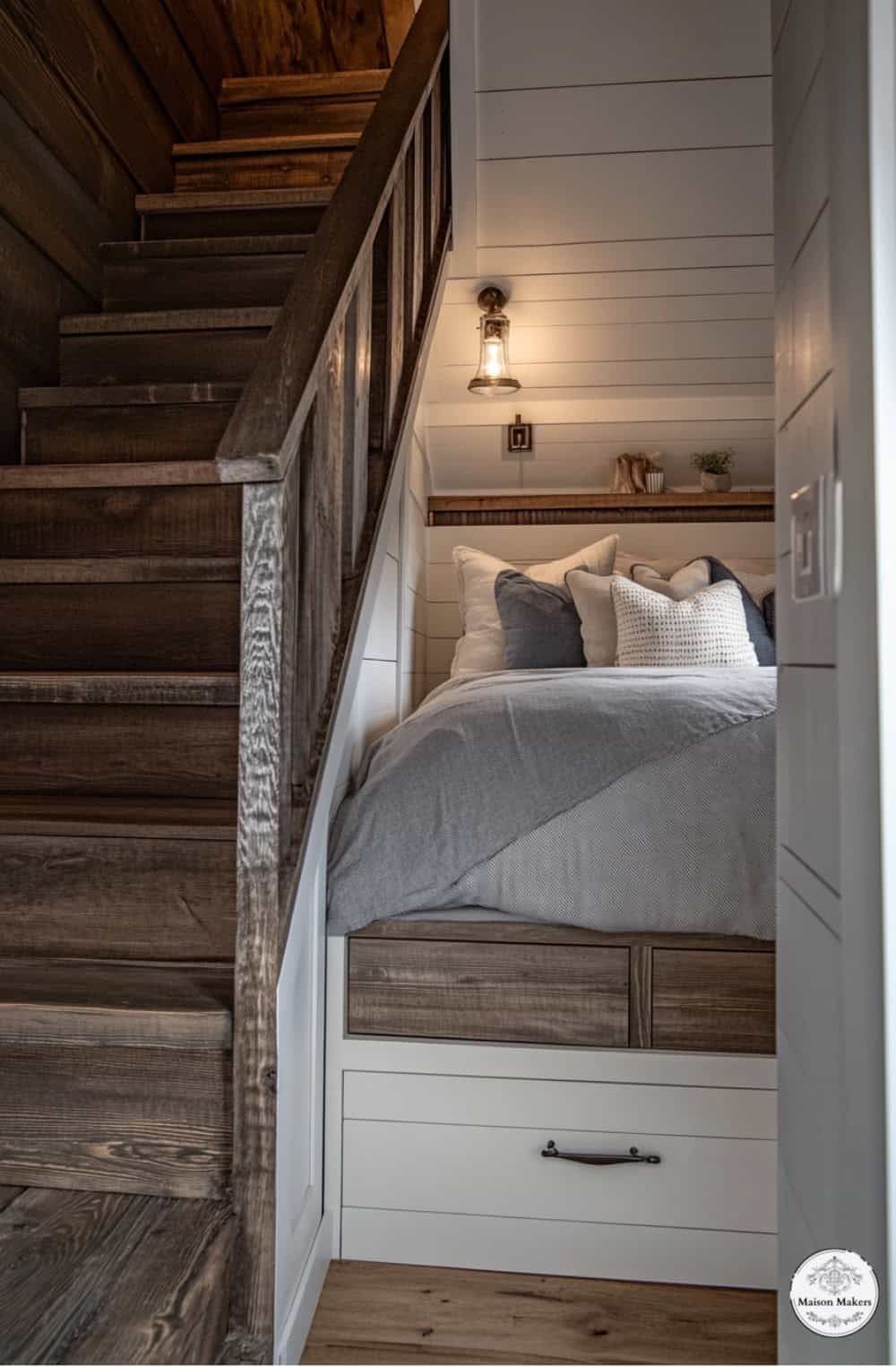 a bed sitting under a wooden stair case