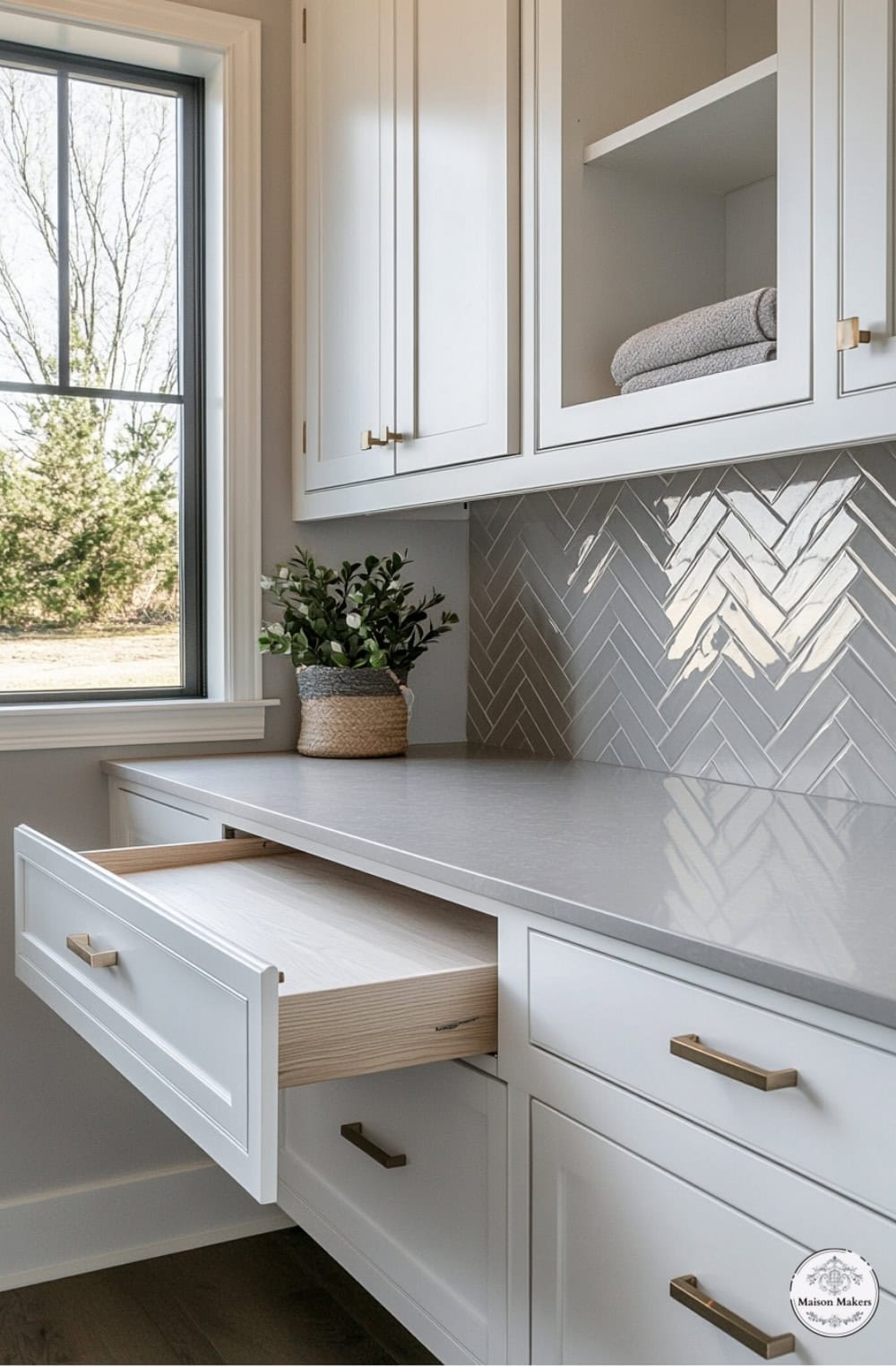 a kitchen with white cabinets and a window