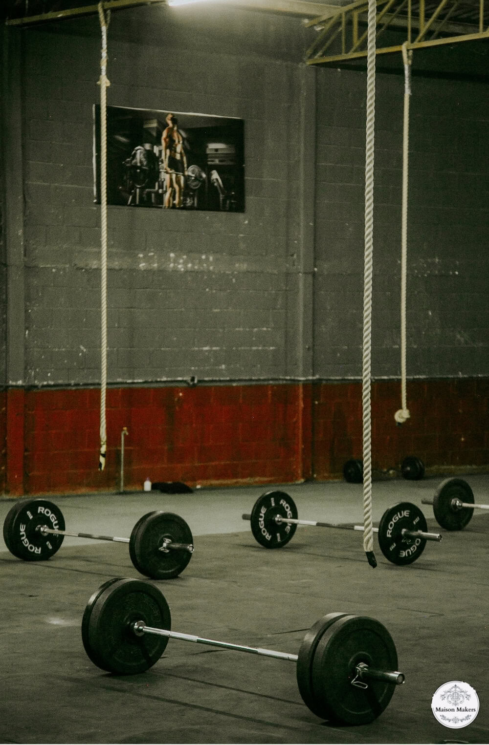 a gym with barbells and a television on the wall