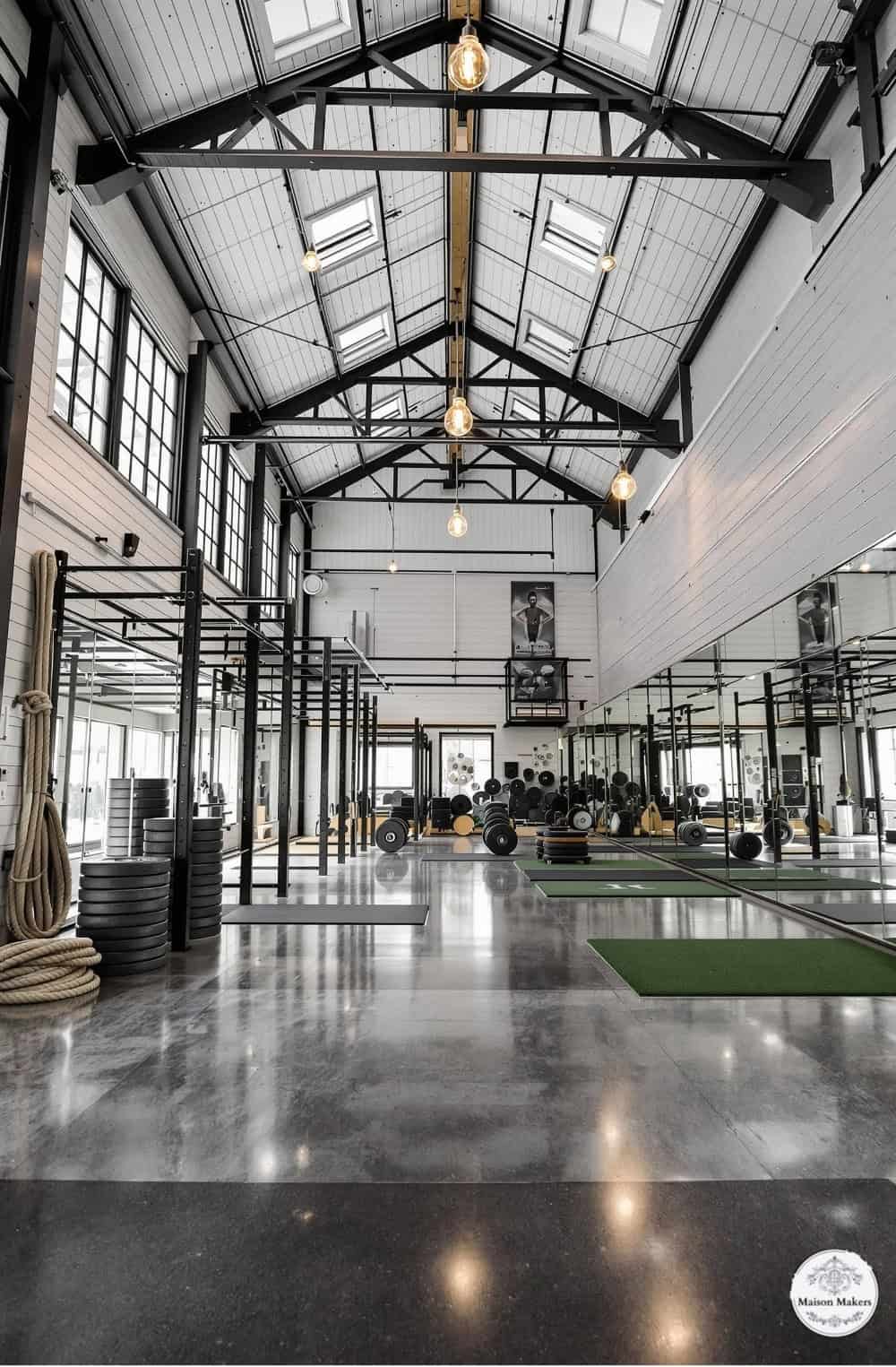 a large gym with a lot of mirrors on the wall