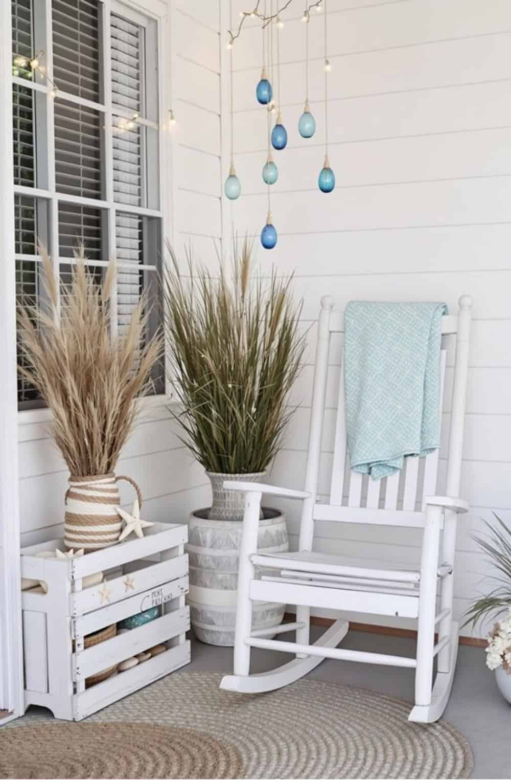 a white rocking chair sitting on top of a porch