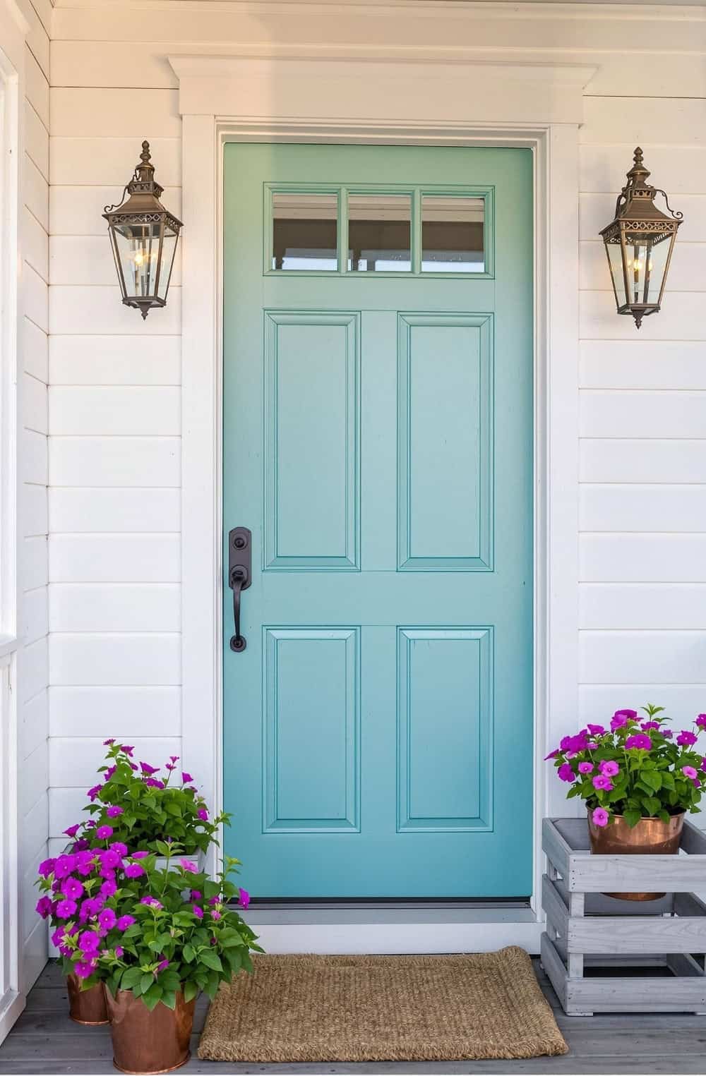 a blue front door with two potted flowers