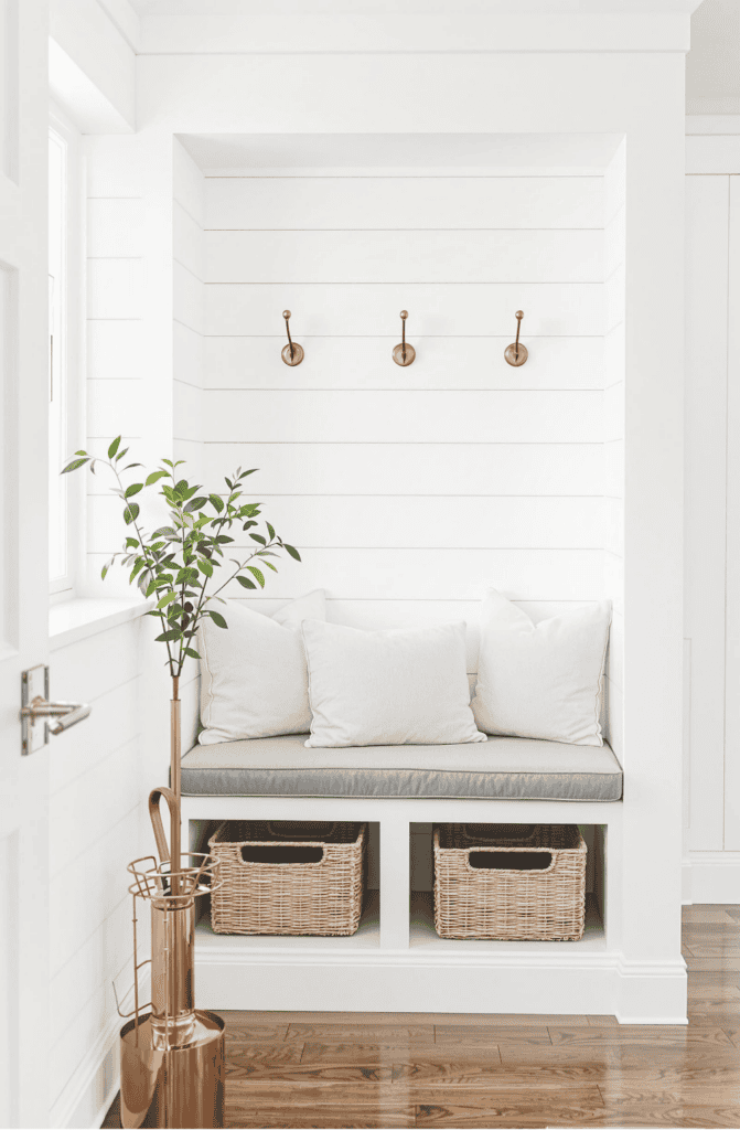 a white bench with two baskets underneath it