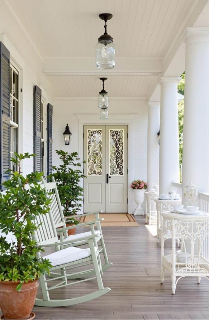 a porch with rocking chairs and potted plants