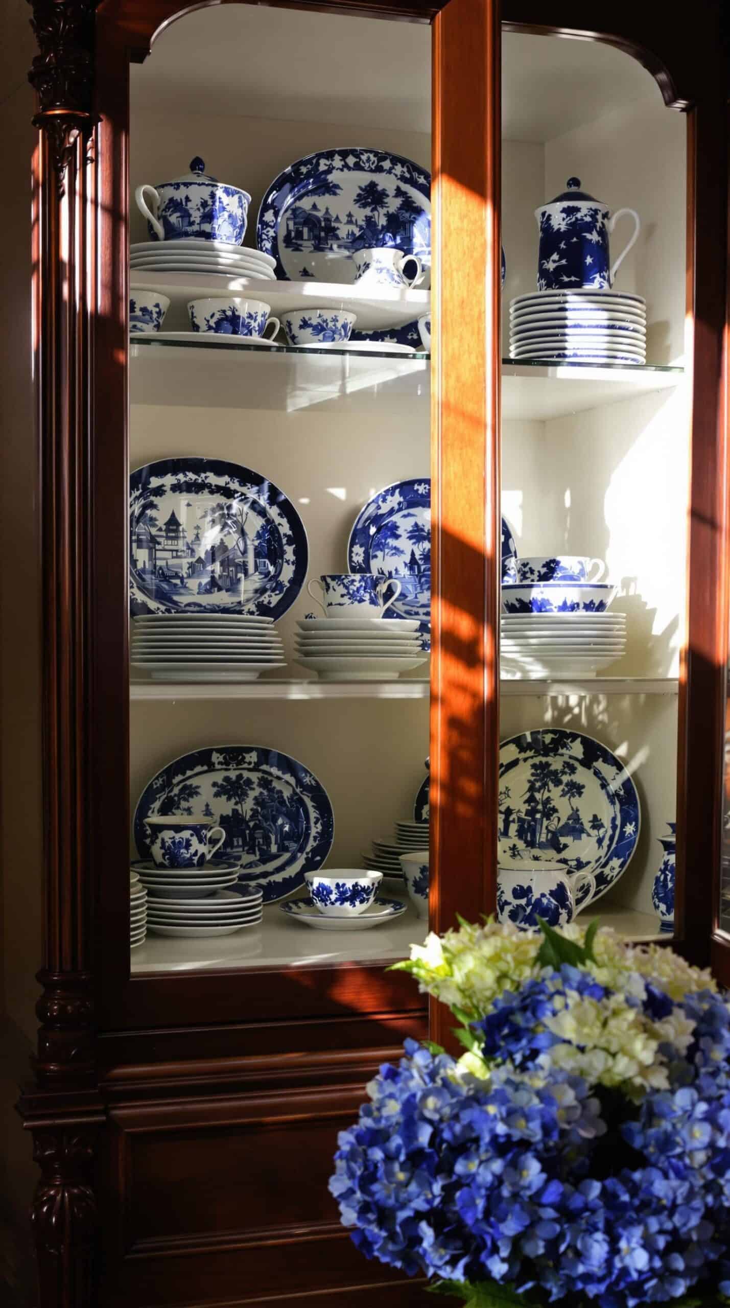 a china cabinet with blue and white plates on it