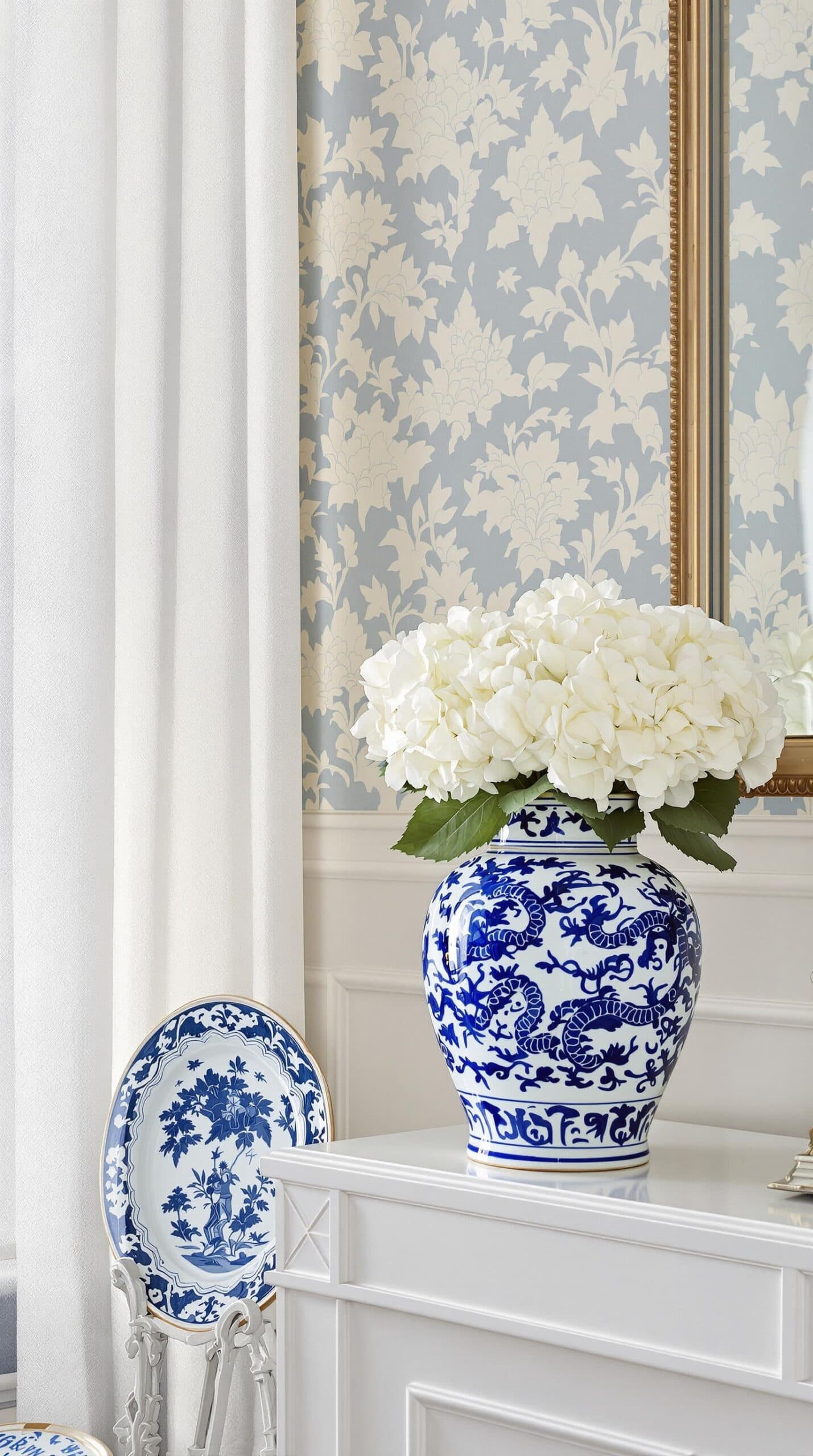 a blue and white vase with white flowers in it
