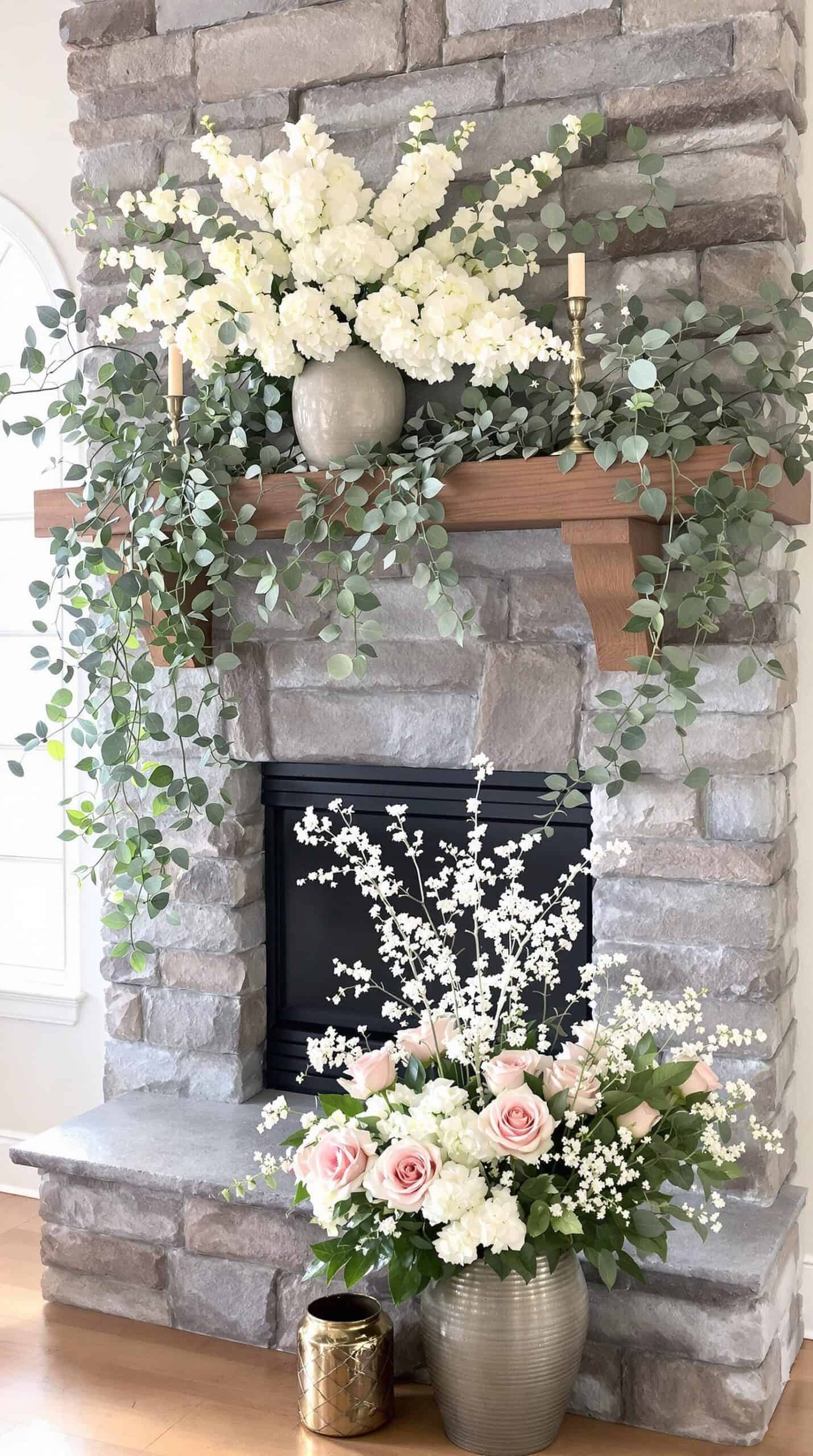 a fireplace decorated with flowers and greenery