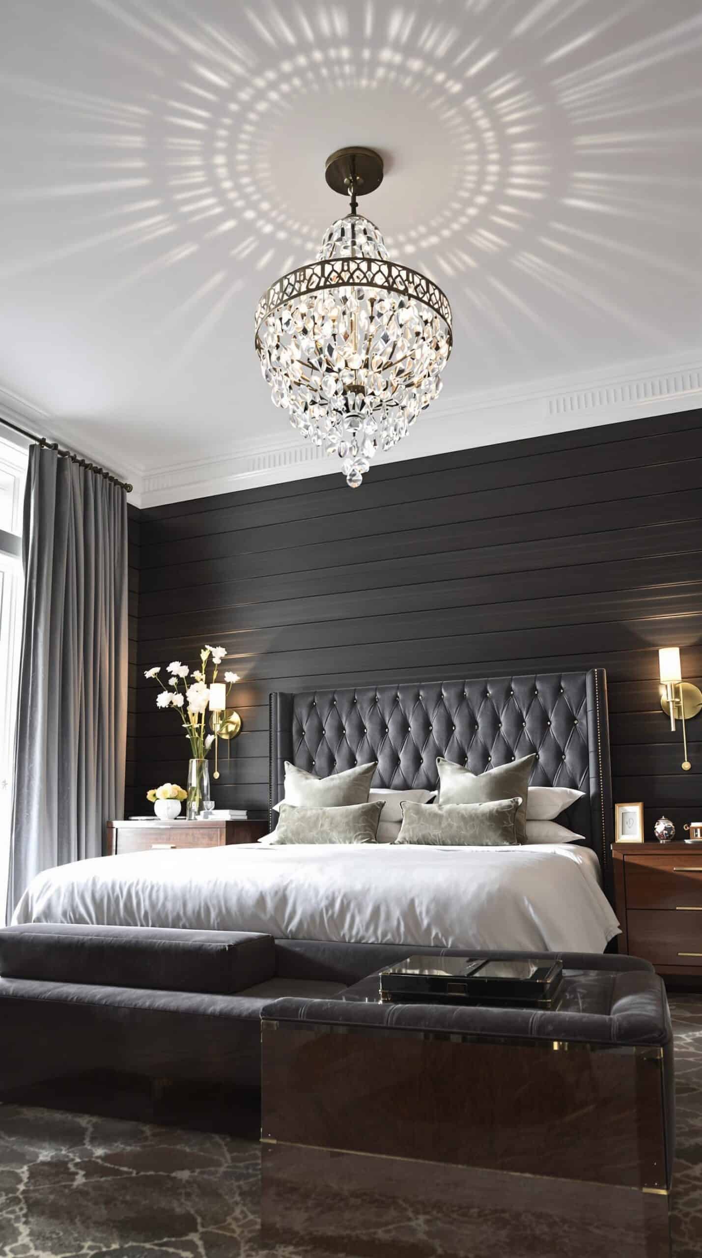 a bedroom with a large bed and a chandelier